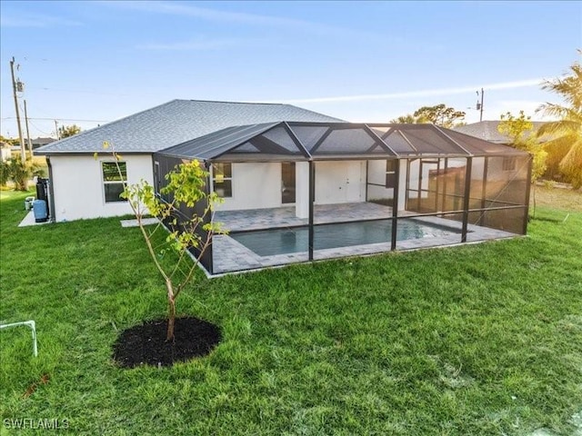 back of house with glass enclosure, a yard, and a patio