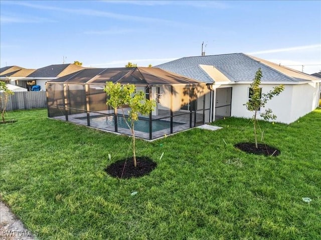 back of property featuring a fenced in pool, a lanai, and a lawn