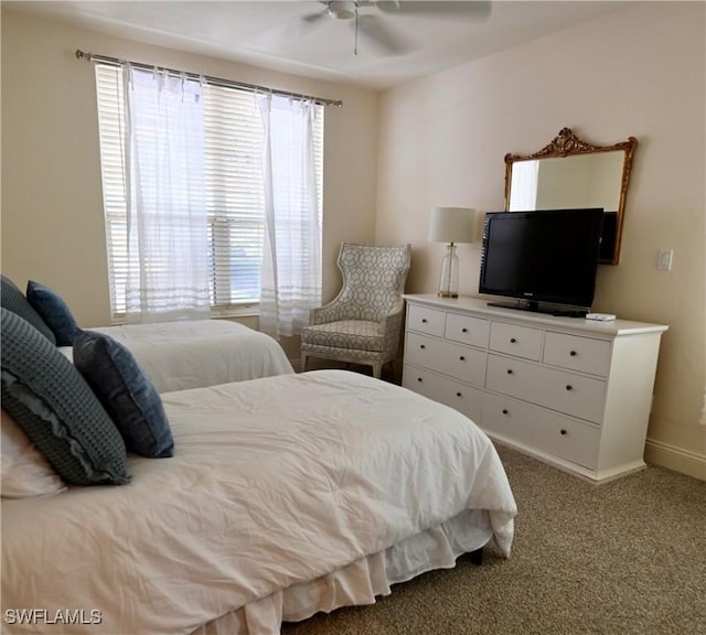 carpeted bedroom with ceiling fan and baseboards