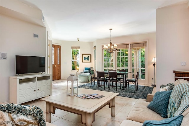 living area with light tile patterned floors, visible vents, and a chandelier