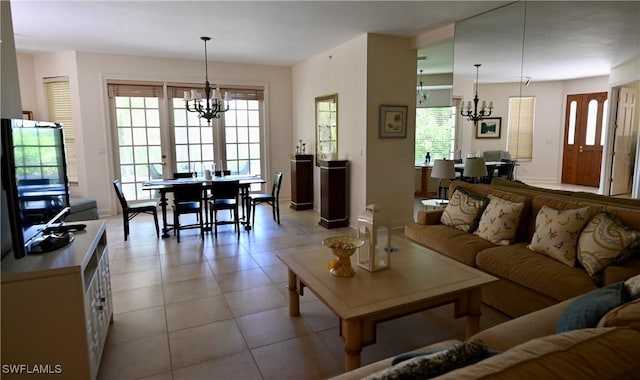 living area featuring a healthy amount of sunlight, light tile patterned flooring, and an inviting chandelier