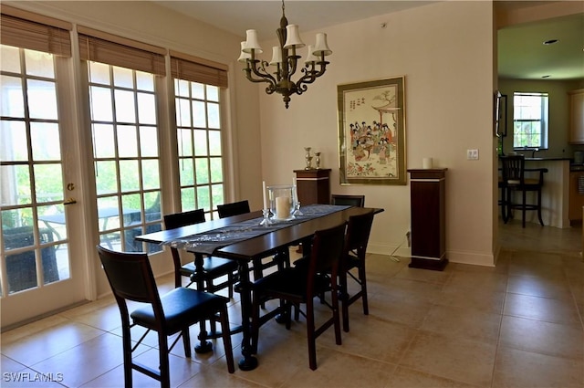 dining space with light tile patterned floors, baseboards, and an inviting chandelier