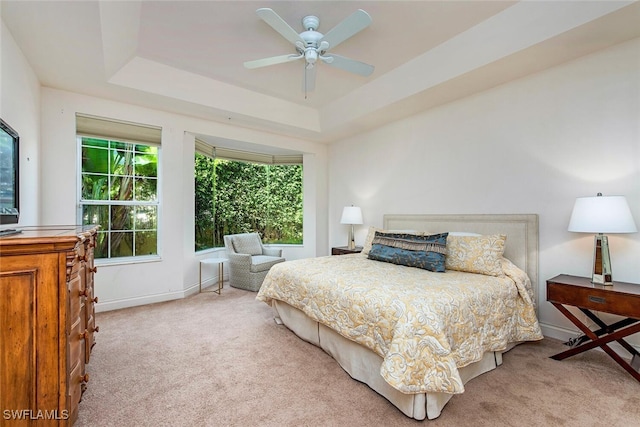 bedroom featuring carpet floors, baseboards, and a tray ceiling