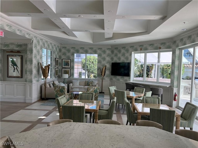 living area with coffered ceiling, a wainscoted wall, crown molding, and wallpapered walls