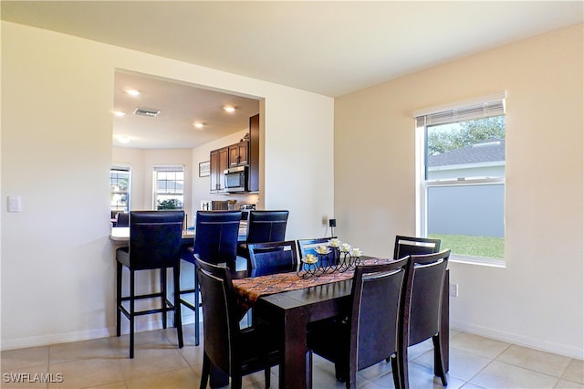 tiled dining space with a healthy amount of sunlight