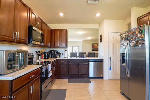 kitchen with sink, light tile patterned flooring, and stainless steel appliances