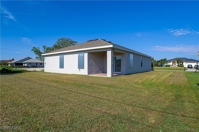 rear view of house featuring a patio area and a lawn