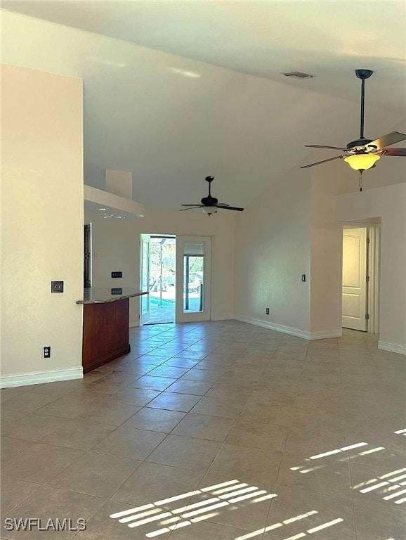 tiled spare room featuring ceiling fan and high vaulted ceiling