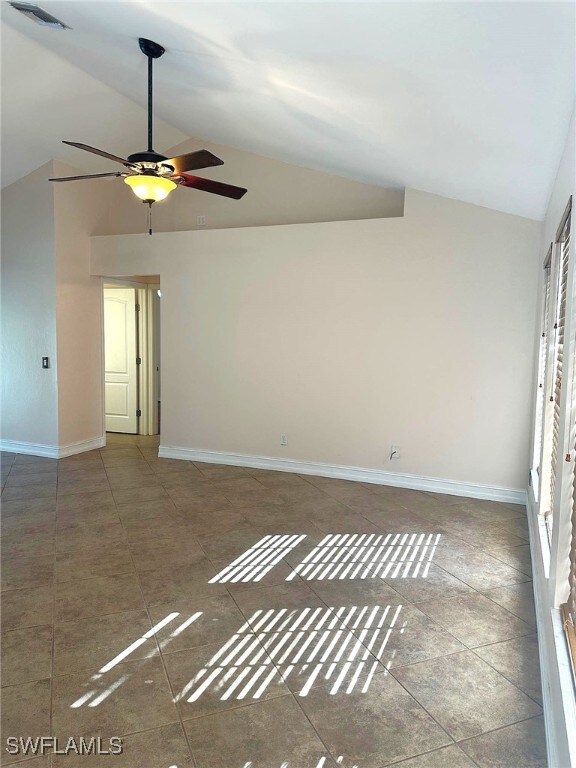 empty room with ceiling fan and vaulted ceiling