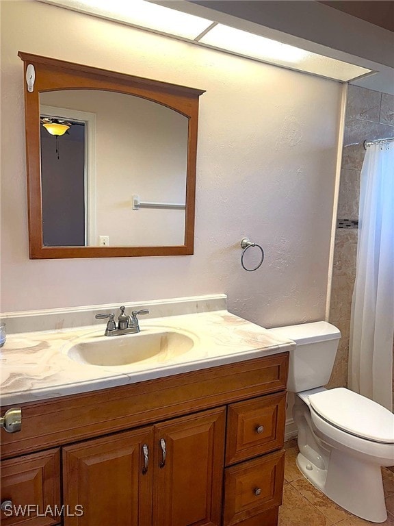 bathroom featuring tile patterned flooring, vanity, curtained shower, and toilet