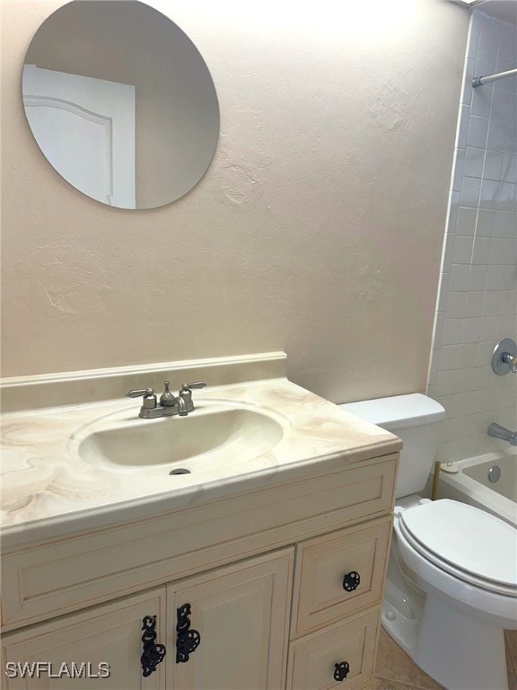 full bathroom featuring vanity, tiled shower / bath combo, and toilet