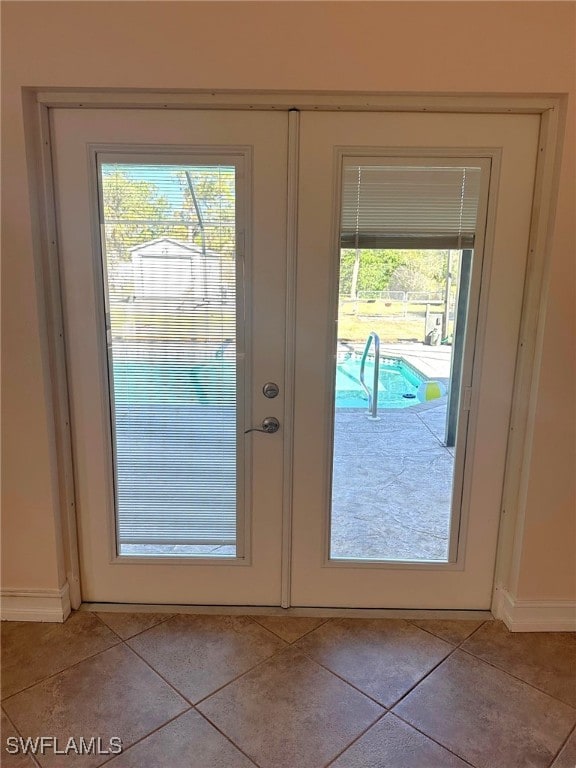 doorway with light tile patterned floors and french doors