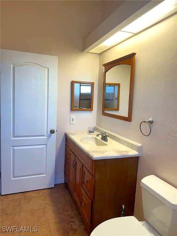 bathroom with tile patterned floors, vanity, and toilet