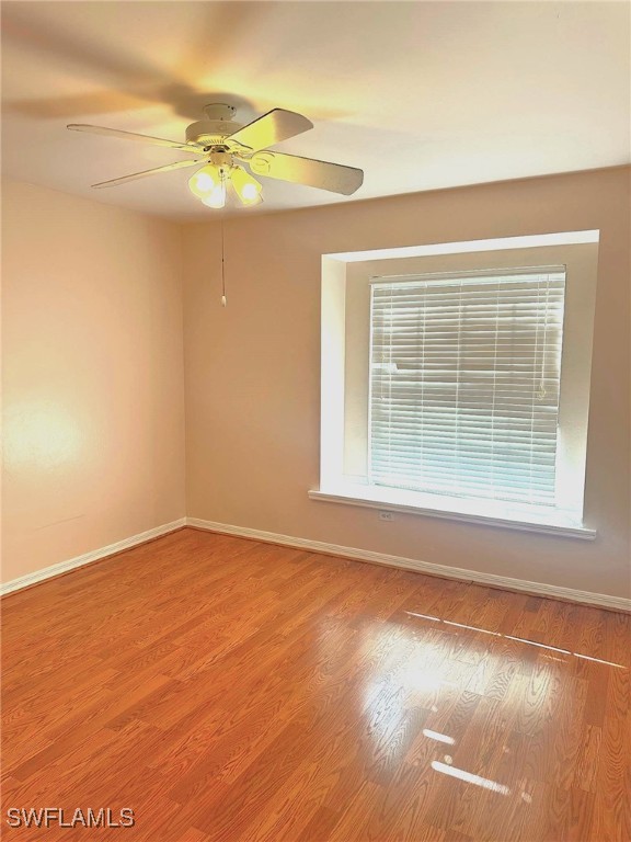 unfurnished room featuring hardwood / wood-style floors and ceiling fan