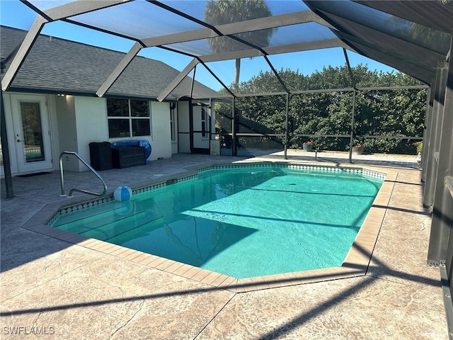 view of pool with a patio and glass enclosure