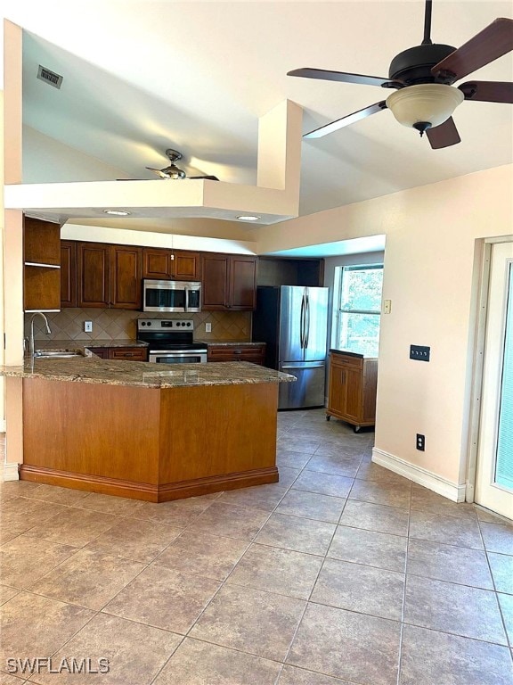 kitchen featuring sink, ceiling fan, stainless steel appliances, decorative backsplash, and kitchen peninsula