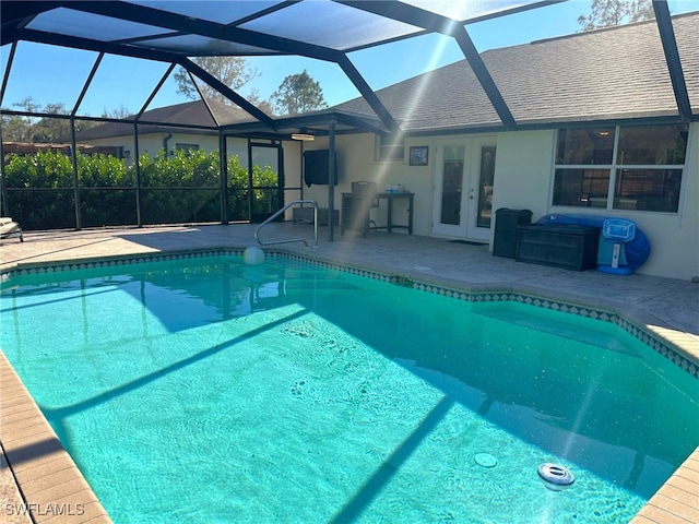 view of pool with french doors, a patio area, and glass enclosure