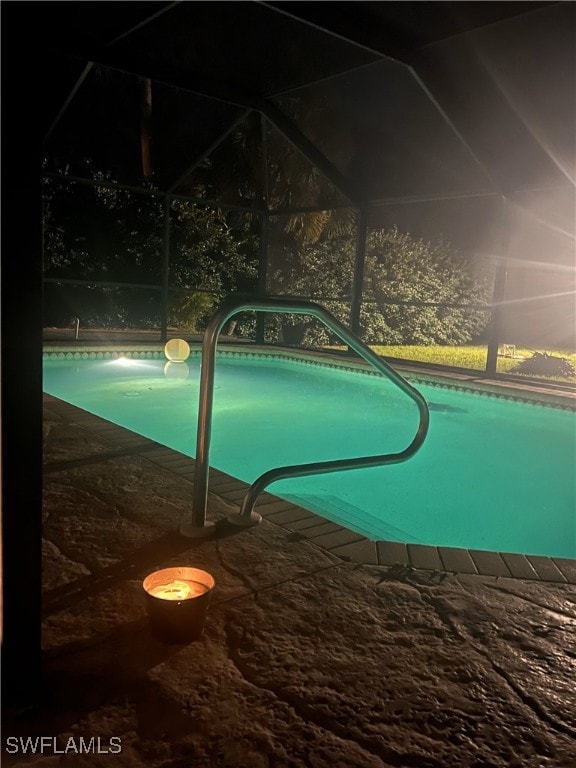 view of swimming pool with glass enclosure