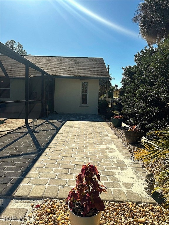 view of patio featuring a lanai