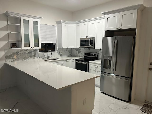 kitchen with sink, tasteful backsplash, kitchen peninsula, stainless steel appliances, and white cabinets