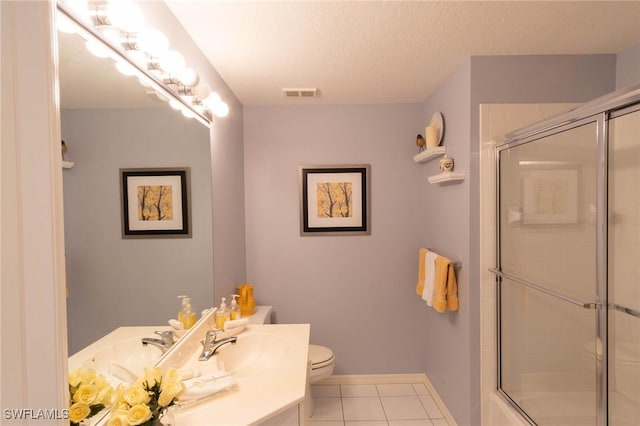 bathroom featuring vanity, a textured ceiling, tile patterned floors, and toilet