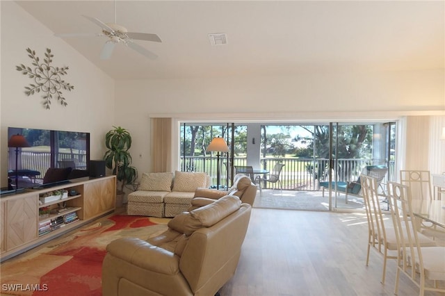 living room featuring hardwood / wood-style flooring, ceiling fan, plenty of natural light, and high vaulted ceiling