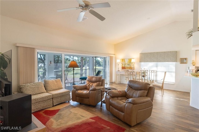 living room with ceiling fan, wood-type flooring, and high vaulted ceiling