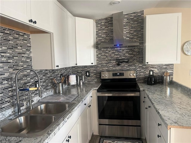 kitchen with sink, wall chimney range hood, backsplash, stainless steel electric stove, and white cabinets