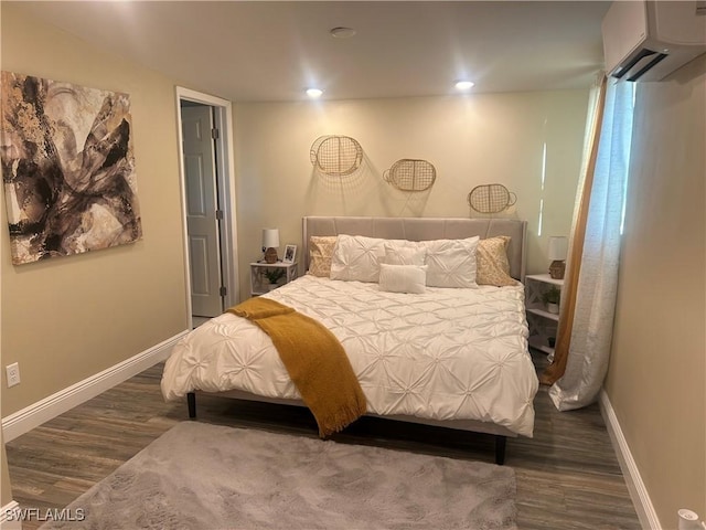 bedroom with an AC wall unit and dark hardwood / wood-style floors