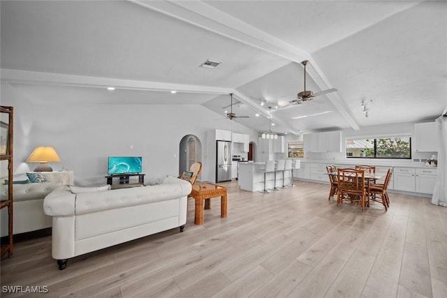 living room featuring ceiling fan, lofted ceiling with beams, and light hardwood / wood-style floors