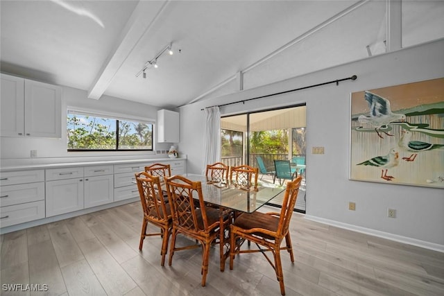 dining area featuring light wood-type flooring, vaulted ceiling with beams, and track lighting