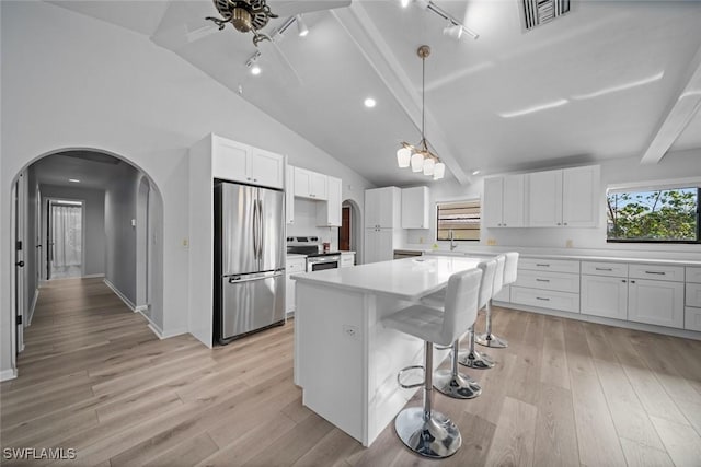 kitchen with white cabinets, decorative light fixtures, light wood-type flooring, and stainless steel appliances