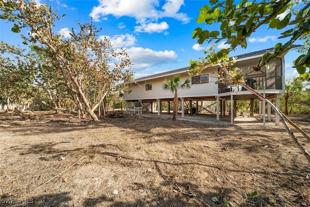 back of house with a sunroom and a carport