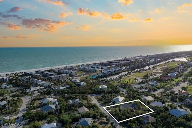 aerial view at dusk featuring a water view