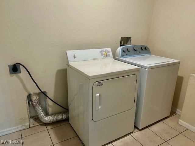 laundry area with separate washer and dryer and light tile patterned flooring