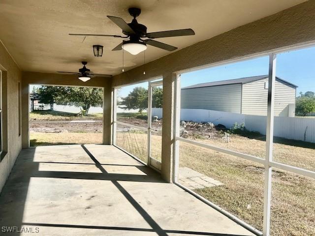 unfurnished sunroom with ceiling fan