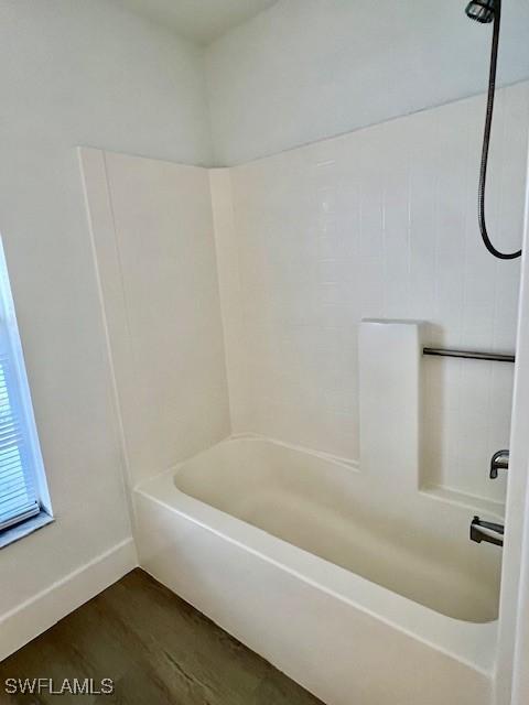 bathroom with shower / bath combination and hardwood / wood-style floors