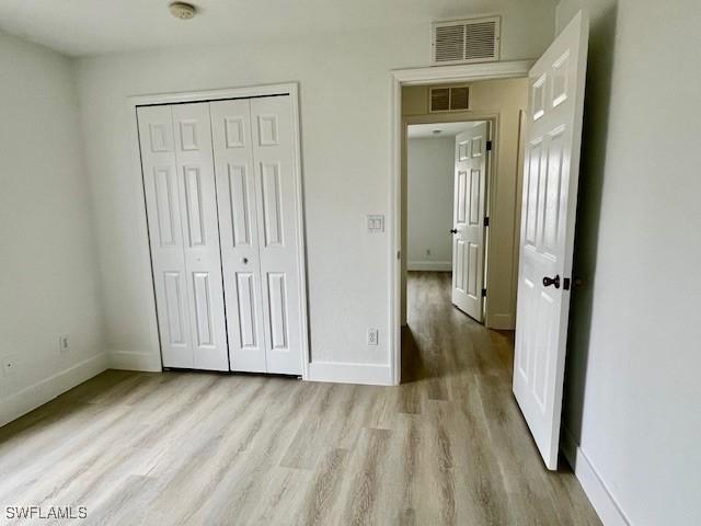 unfurnished bedroom with light hardwood / wood-style floors and a closet