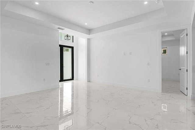 spare room featuring a raised ceiling and french doors