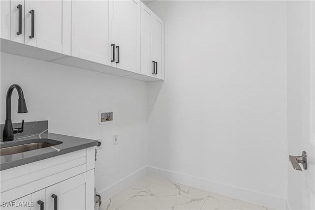 clothes washing area with cabinets, hookup for a washing machine, hookup for an electric dryer, and sink