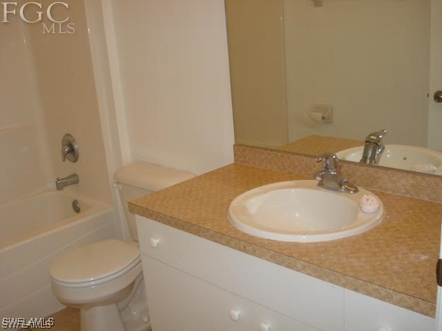 full bathroom with toilet, vanity, and tub / shower combination