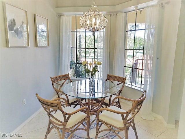 tiled dining room featuring a chandelier and a healthy amount of sunlight