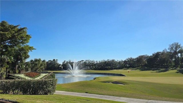 surrounding community with a yard and a water view