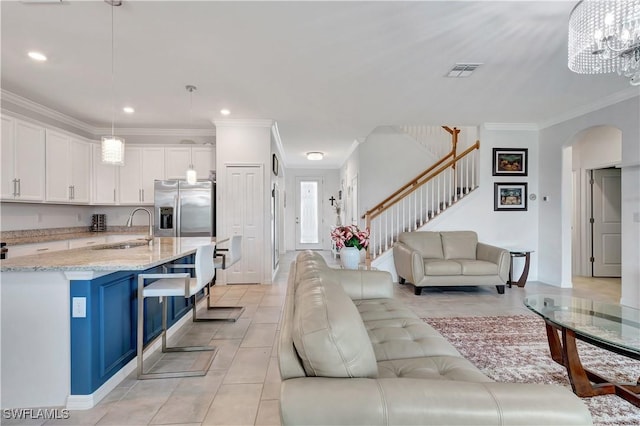 tiled living room with an inviting chandelier, ornamental molding, and sink