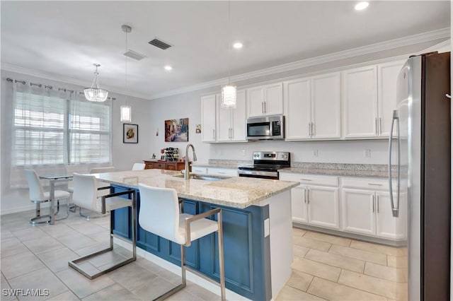 kitchen featuring white cabinetry, sink, hanging light fixtures, stainless steel appliances, and a center island with sink