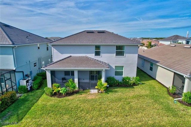 2122 Hamlin St, Naples, FL 34120 - back of property with a sunroom, a tiled roof, and a lawn