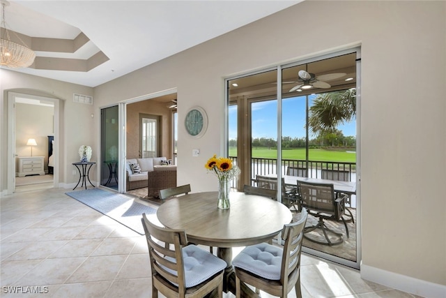 tiled dining room featuring a water view and ceiling fan