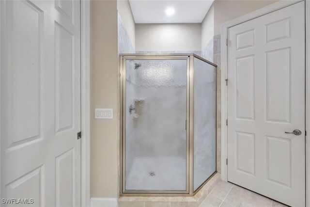 bathroom featuring tile patterned flooring and a shower with shower door