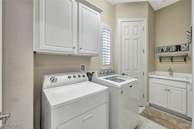 washroom featuring sink, light tile patterned flooring, cabinets, and independent washer and dryer