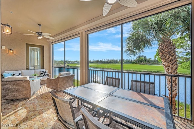 sunroom with a water view and ceiling fan